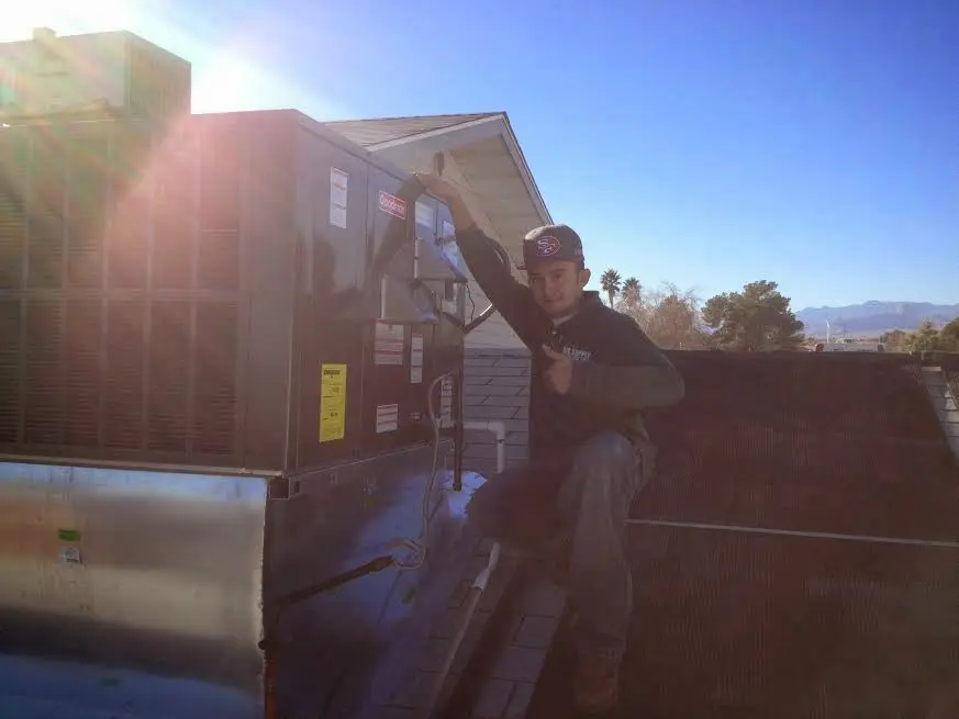 HVAC technician performing AC Tune-Up on a rooftop unit in St. Paul Park